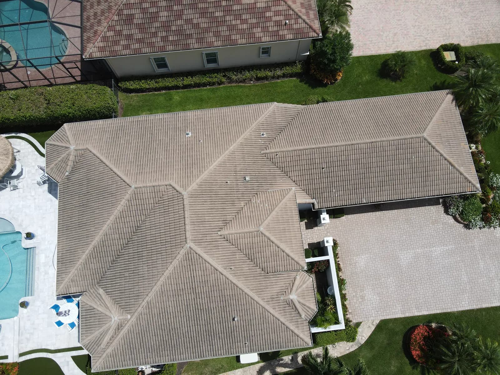 Aerial drone overview of a single-story home's concrete tile hip roof, used to document the full roof surface during an inspection